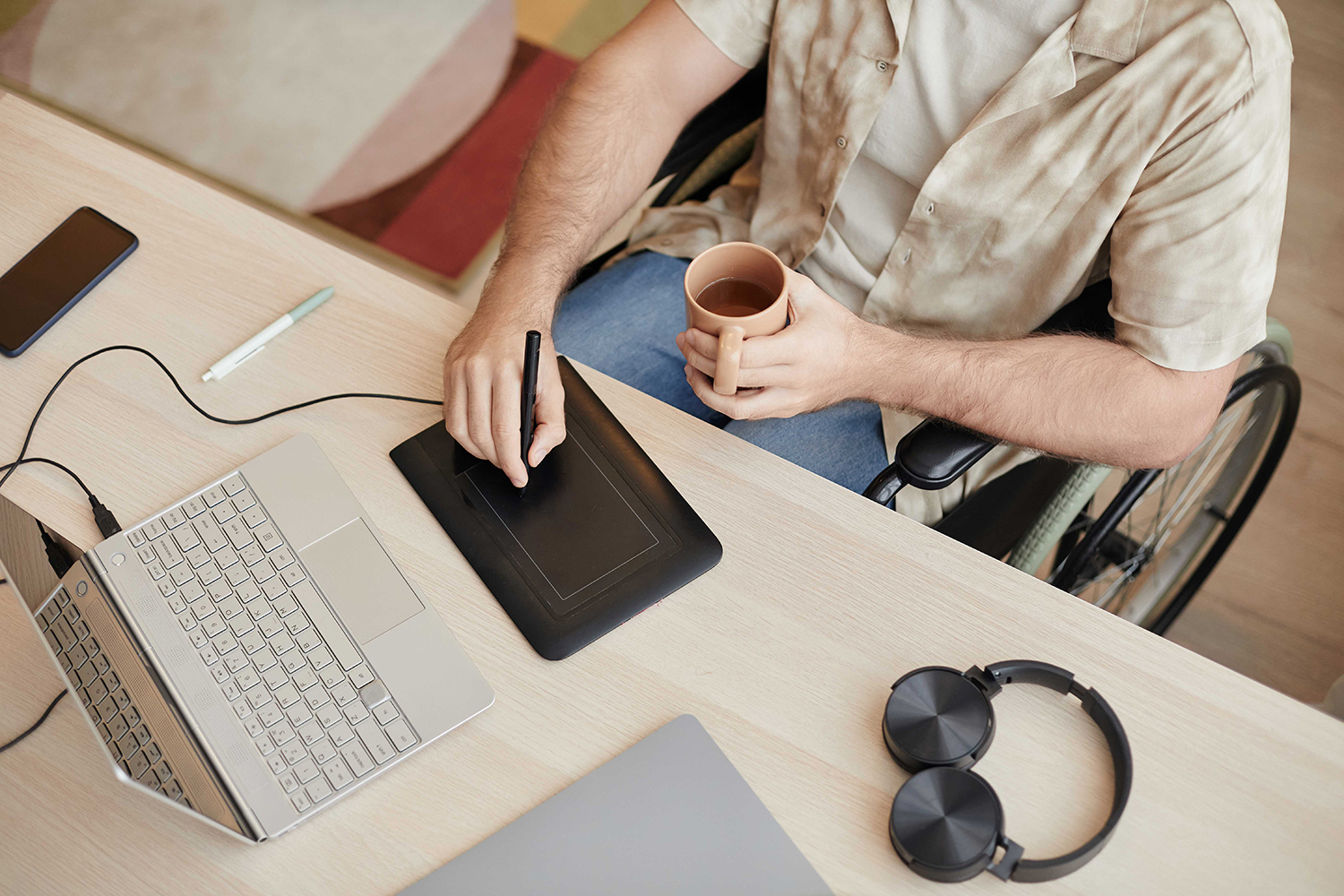 Mann im Rollstuhl arbeiten am Laptop